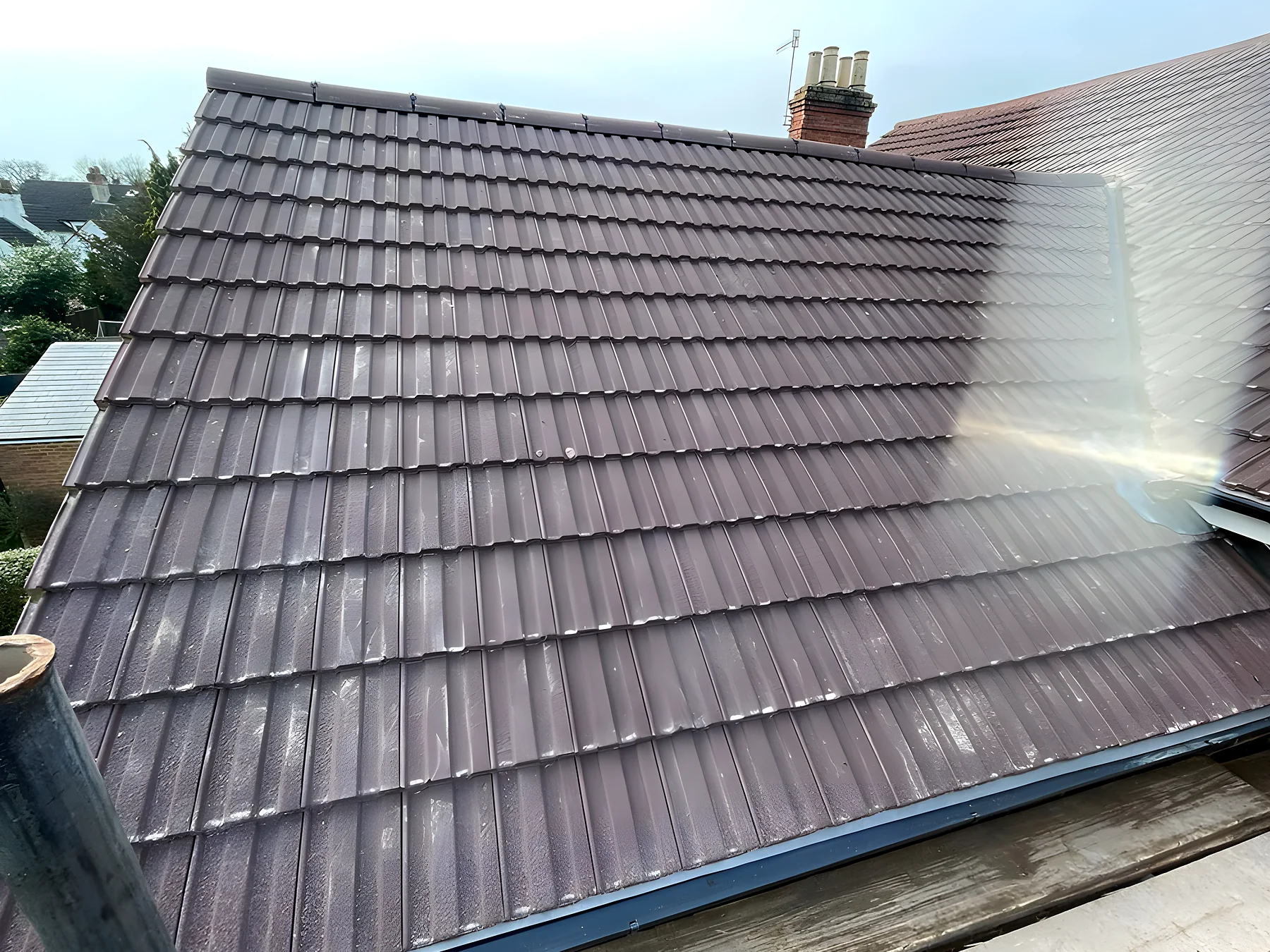 A newly tiled roof slope against a blue sky, the job complete