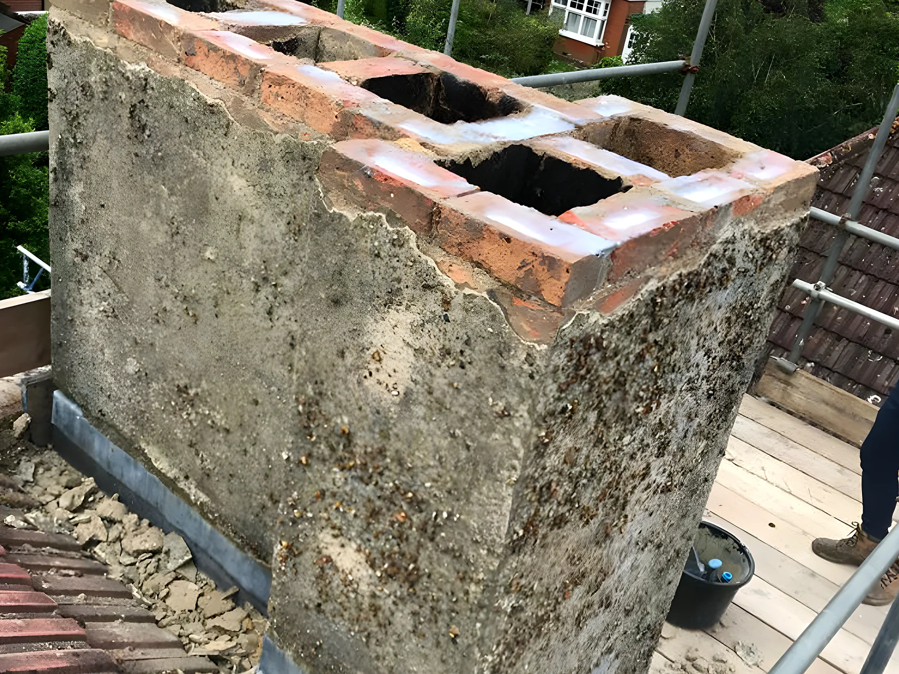 Weathered chimney stack with open mortar joints before repointing