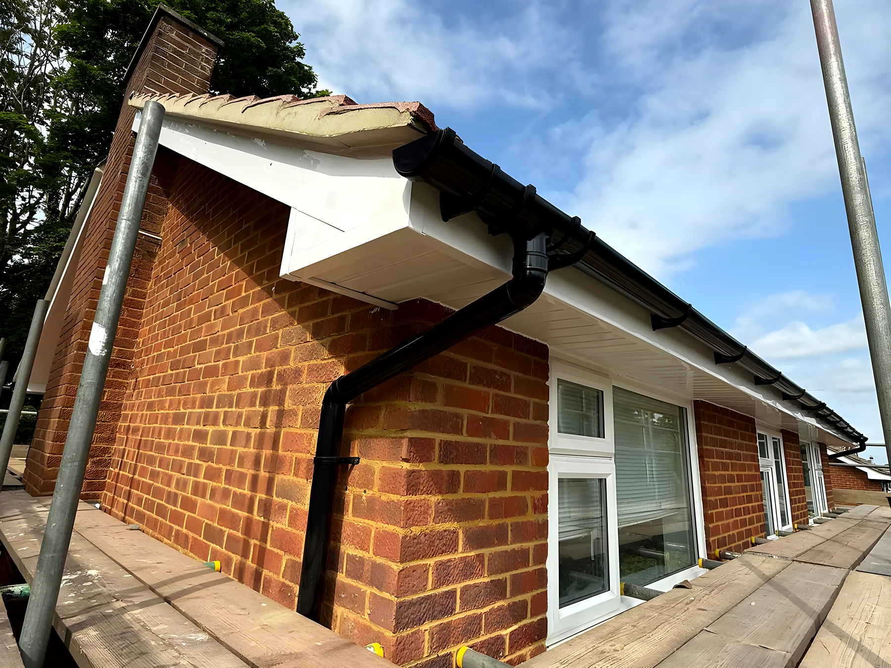 New guttering run along the eaves of a brick house