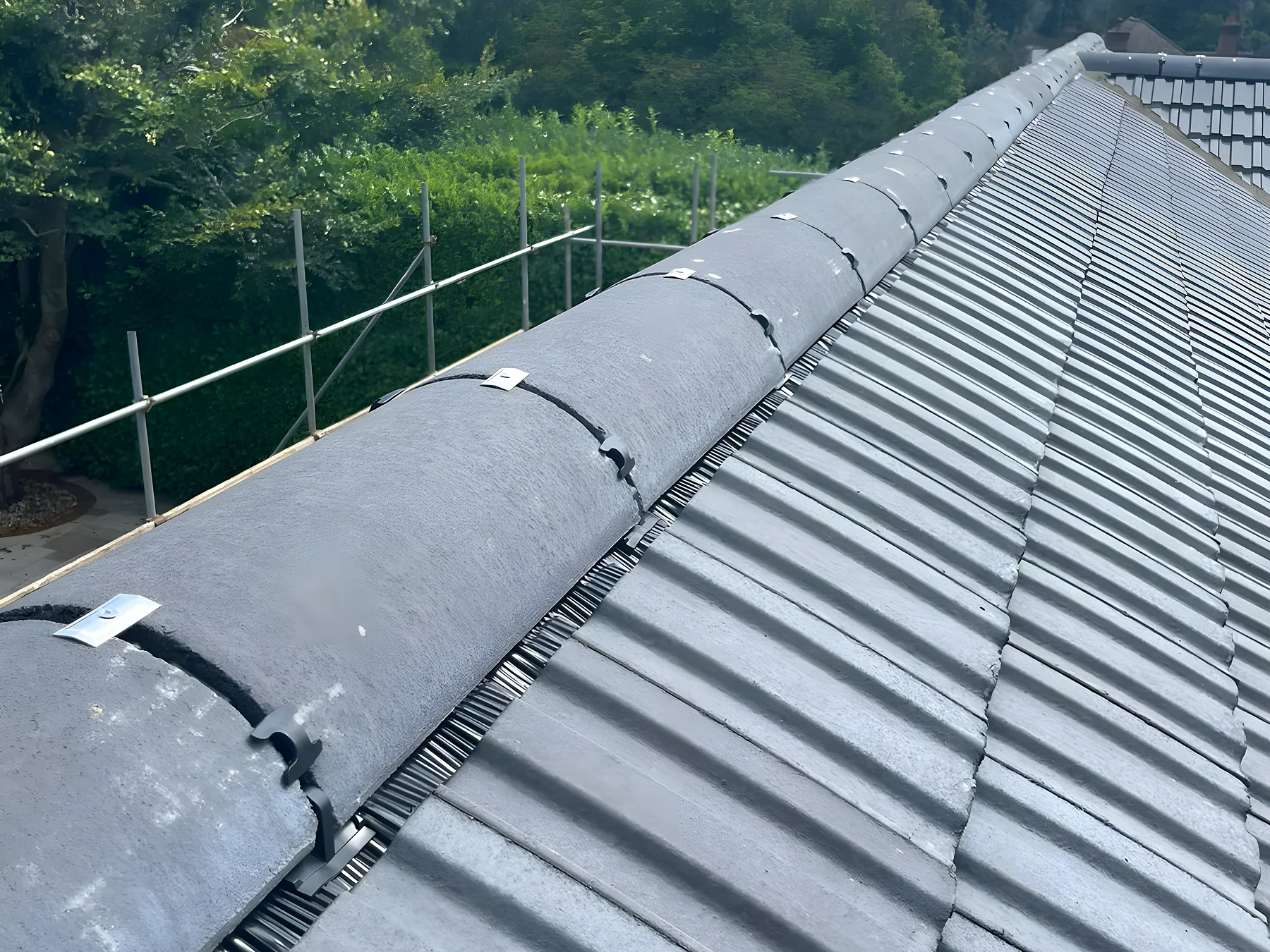 New grey interlocking tiles laid and fixed up to the ridge
